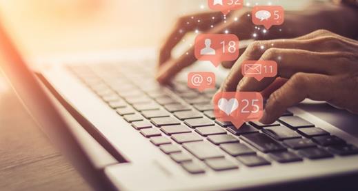 Digital Marketing with Co-op Fingertips typing on a computer with like icons popping out of the keyboard.