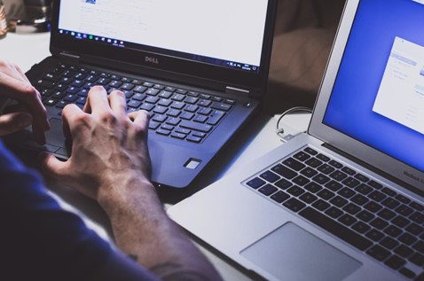 Man typing, coding and posing for photo