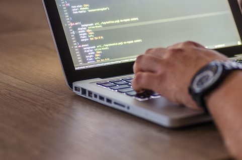 Man typing, coding and wearing watch