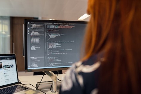 Woman typing, coding looking into system