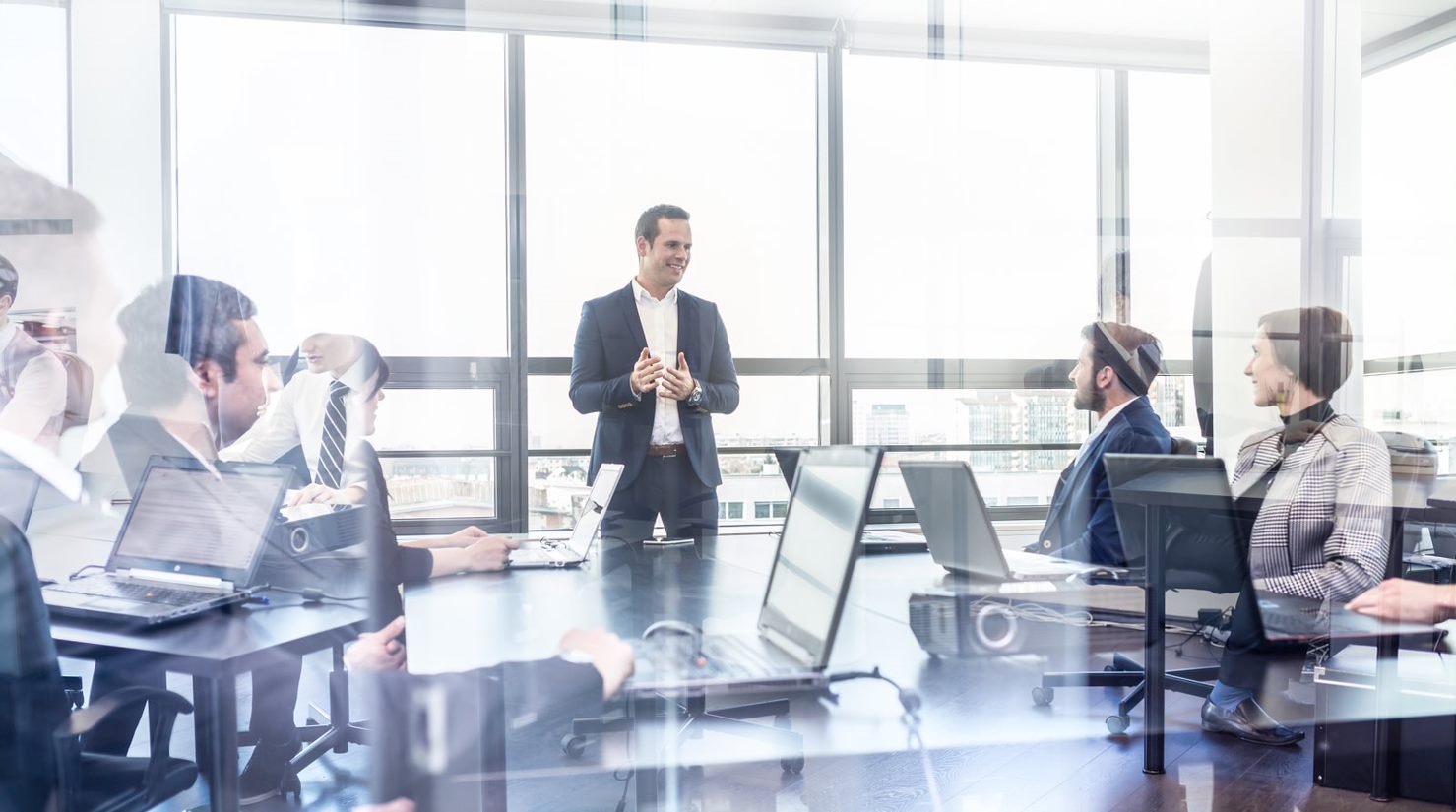 Attendees in conference room, man lecturing