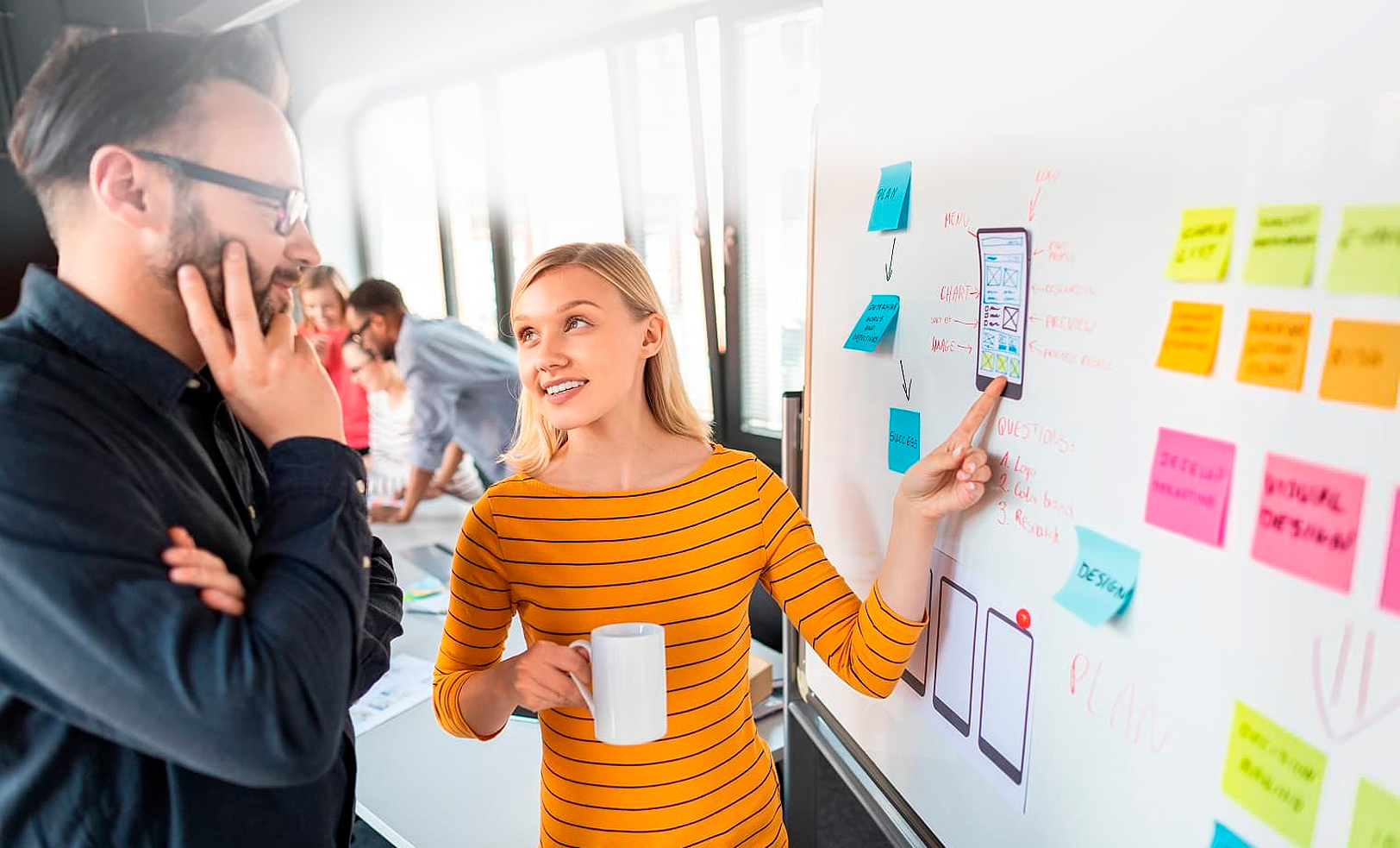 Woman presenting at whiteboard, man listening