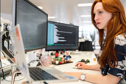 Woman typing, clicking mouse, posing for photo