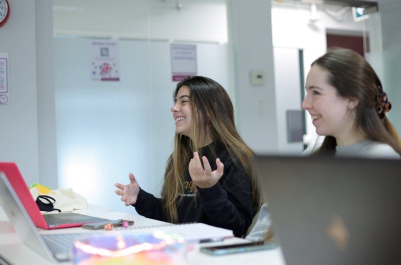 Two women smiling and answering questions