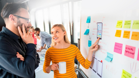 Woman explaining by showing white board, Man listening