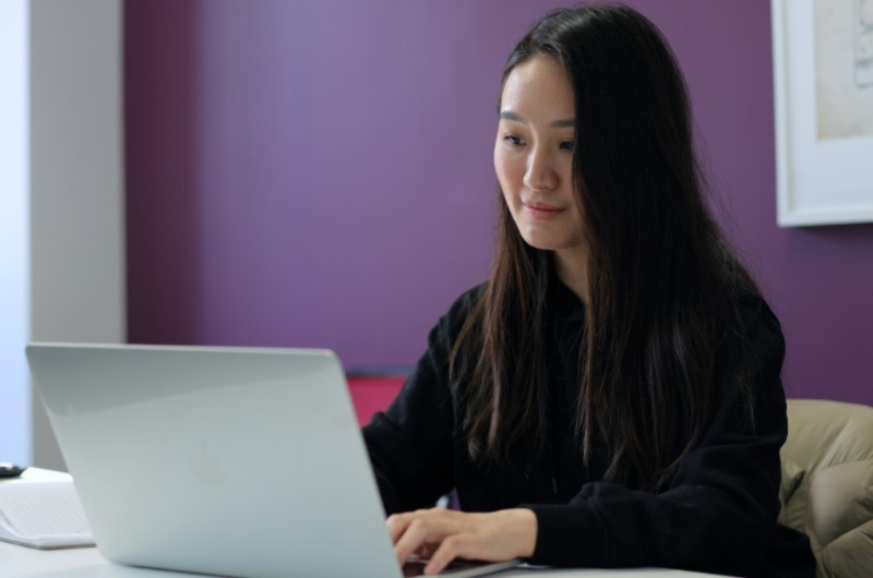 Woman typing, smiling for photo