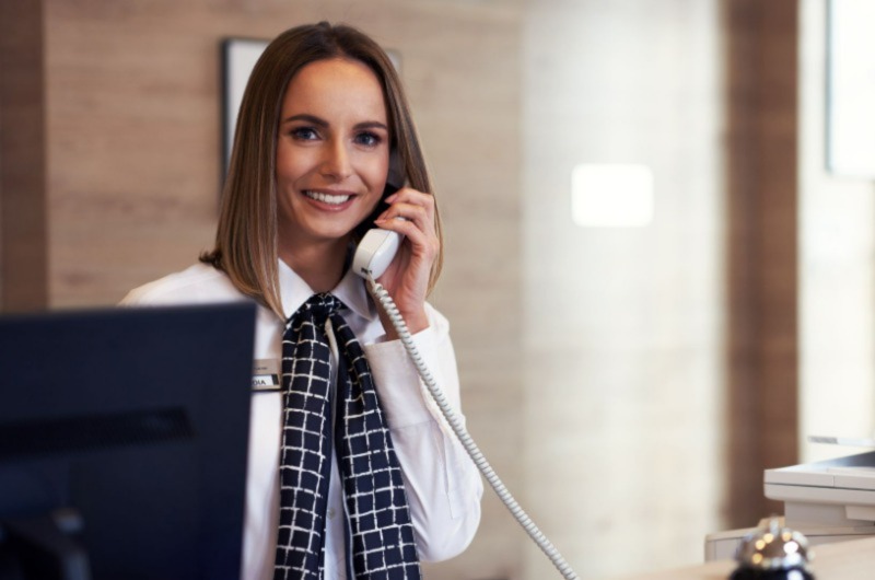 woman speaking on the phone, smiling and posing for a photo