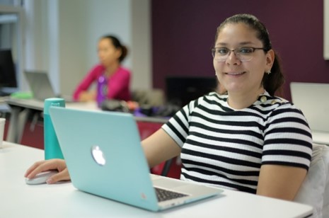 Woman smiling, clicking mouse, posing for photo