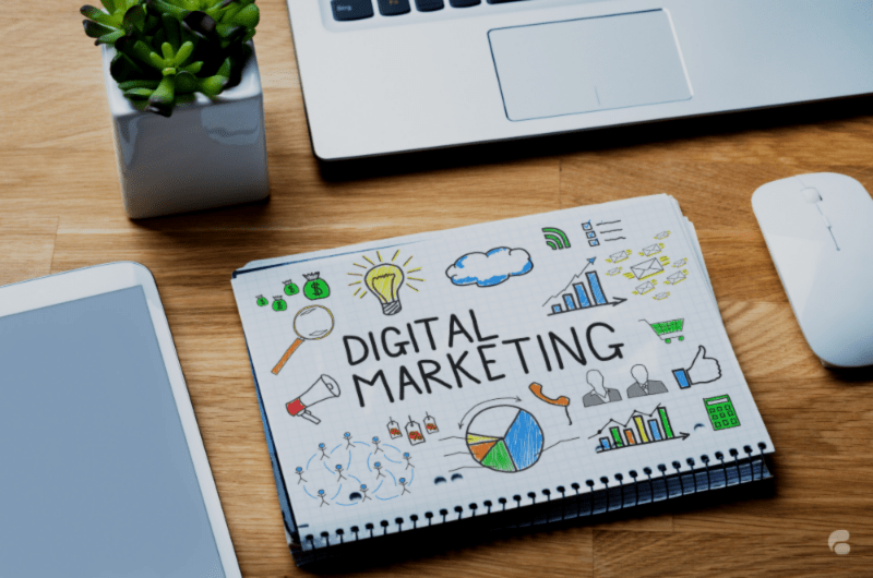 On the table: mouse, laptop, and digital marketing book