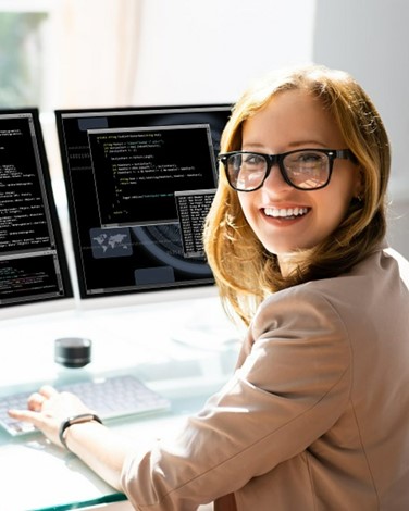 Woman smiling, typing, wearing glasses, posing for photo