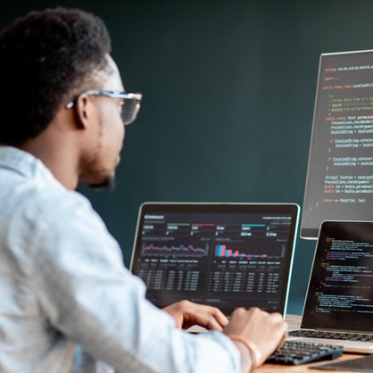Man typing, wearing glasses, posing for photo