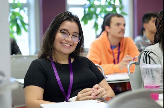 Woman smiling, wearing glasses, posing for photo