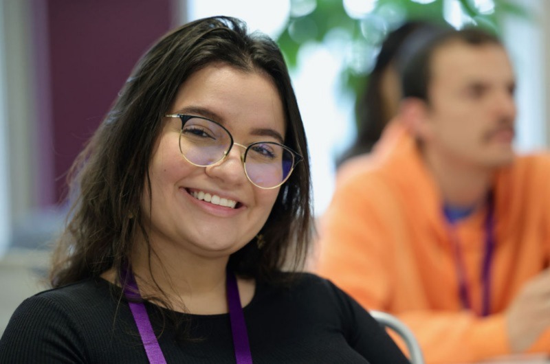 Woman smiling, wearing glassess, posing for photo