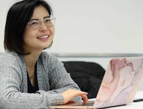 Woman smiling, typing, posing for photo