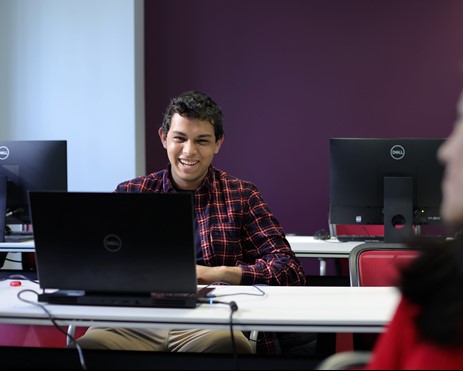 Man smiling, typing, posing for photo