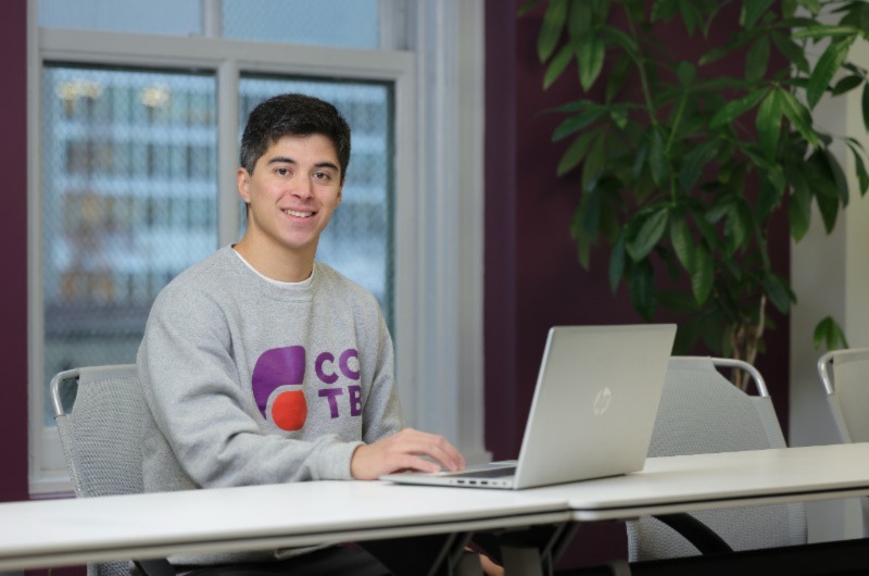 Men typing and smiling for a photo