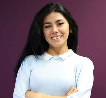 Woman smiling, hands folded, posing for photo