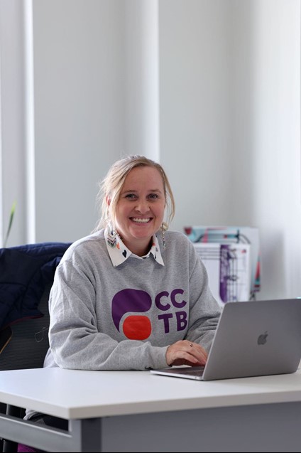 Woman smiling, typing, posing for photo