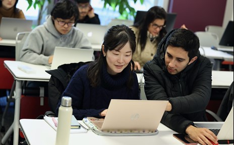 Woman smiling, typing, Man looking into screen, posing for photo