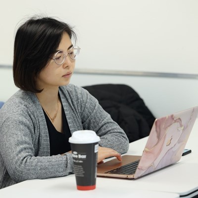 Woman typing, wearing glasses, posing for photo