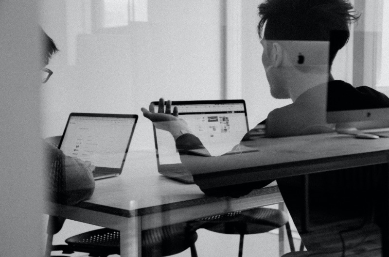 Two Men viewing laptop screen and discussing something