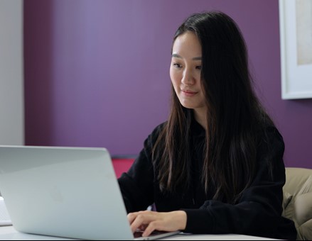 Woman smiling, typing, posing for photo