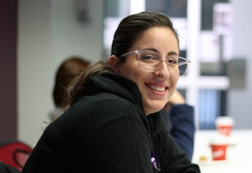 Woman smiling, wearing glasses, posing for photo