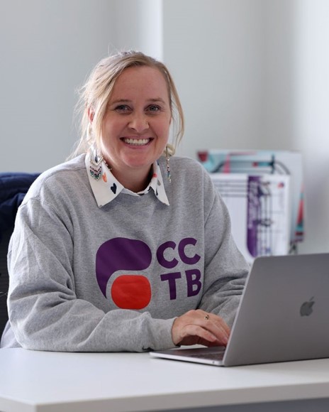 Woman smiling, typing, posing for photo