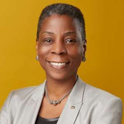 Ursula Burns - smiling, hands folded, posing for a photo