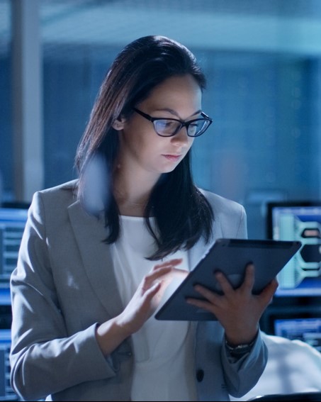 Woman checking in the tablet, wearing glasses, posing for photo