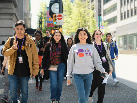 People smiling, walking on street, posing for a photo