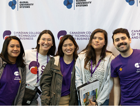 Group of smiles, wearing ID card, posing for photo