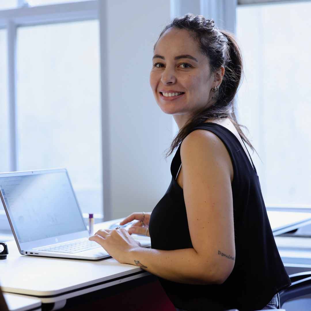 Beautiful woman smiling, typing, posing for a photograph
