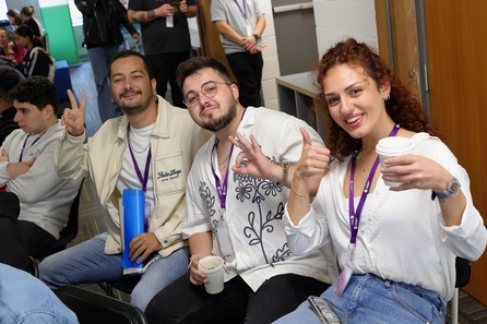 Group smiling, showing victory, posing for a photo