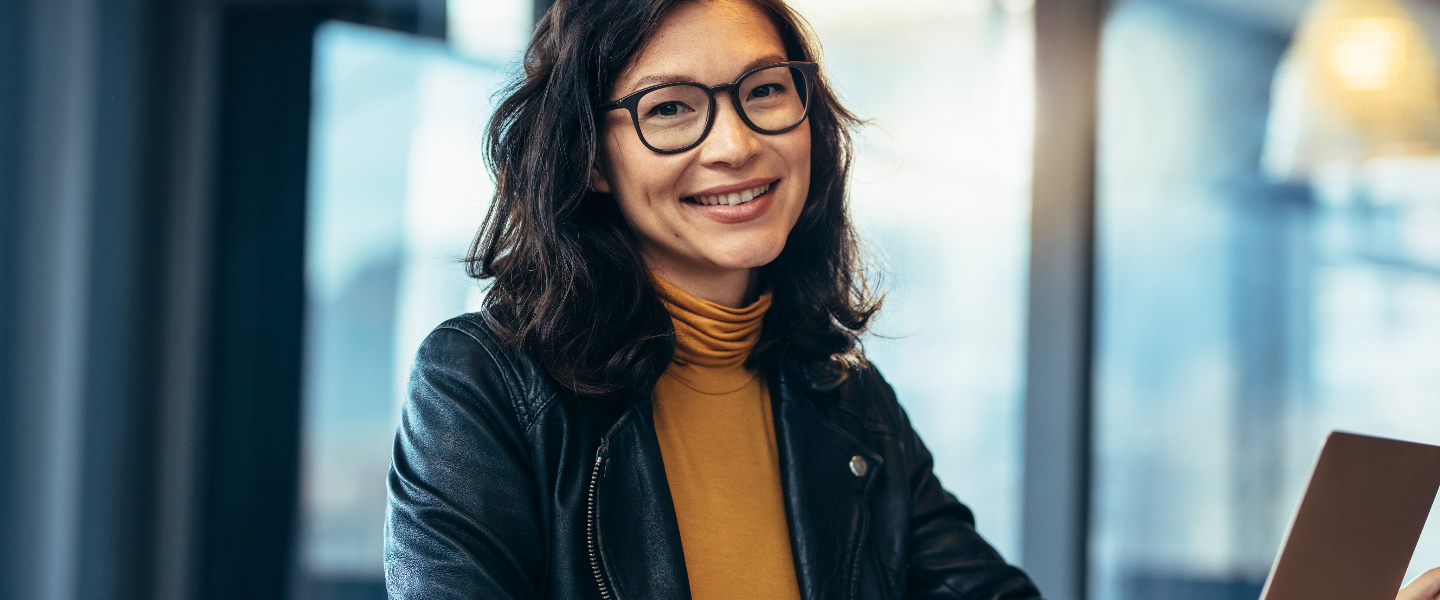 Woman smiling, wearing glasses, posing for a photo