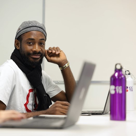 Man smiling, typing , posing for photo