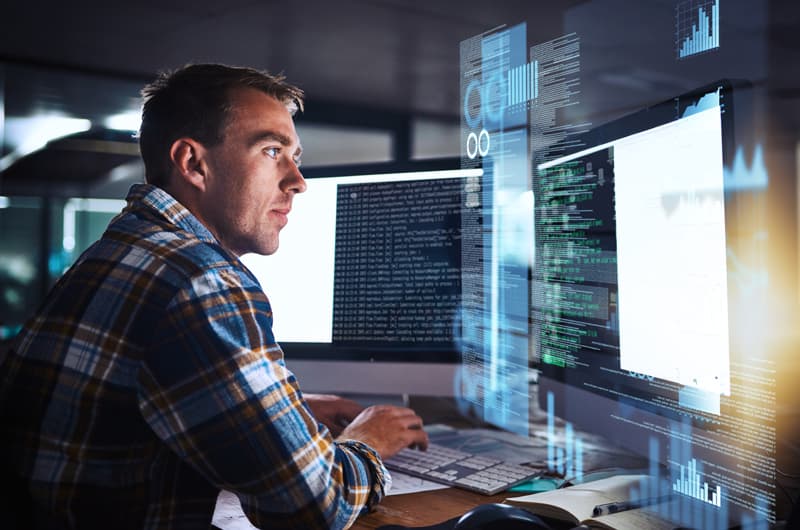 Man typing on a keyboard while looking at the computer screen